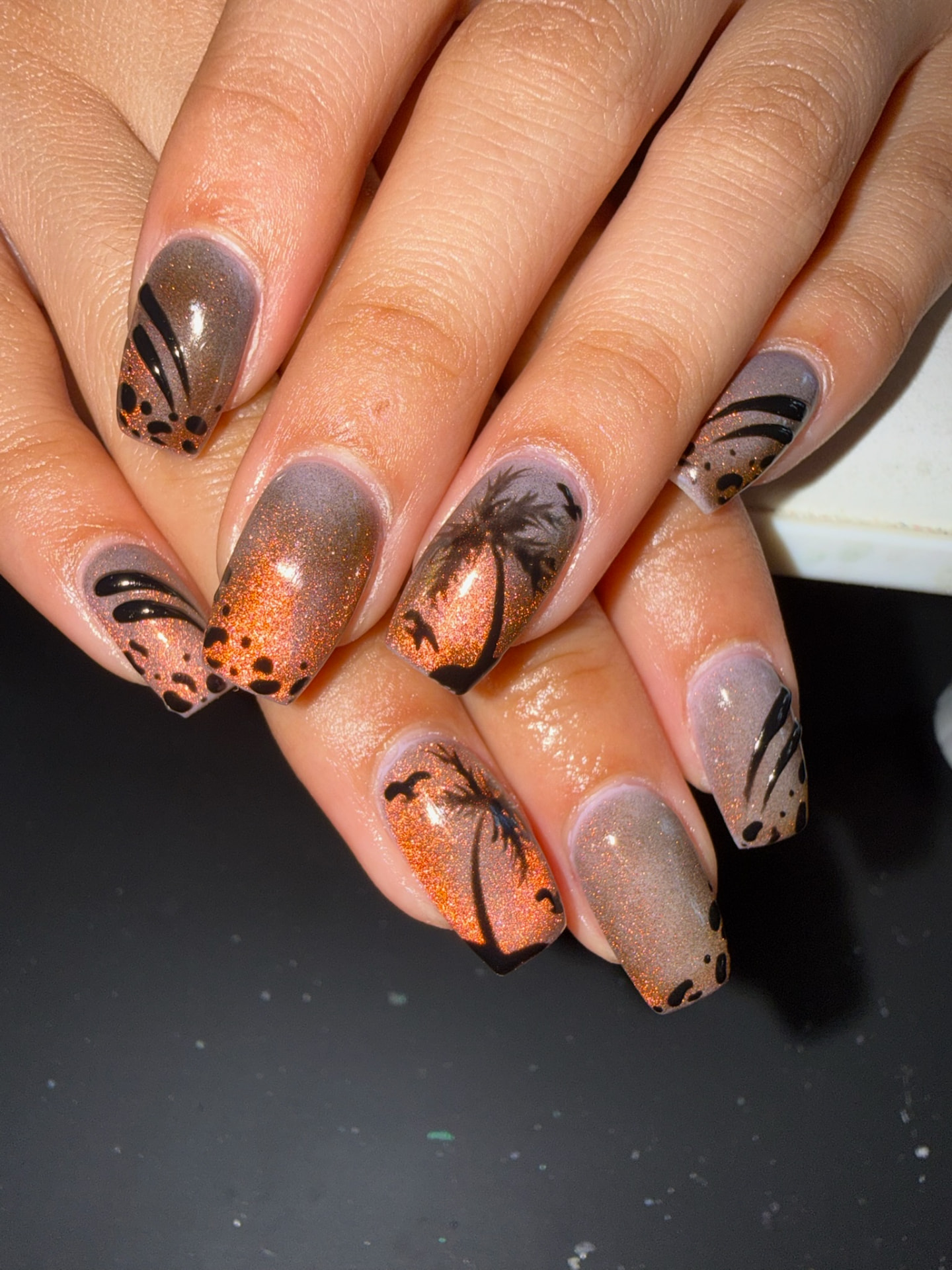 Copper shimmer square nails with black palm trees and abstract details