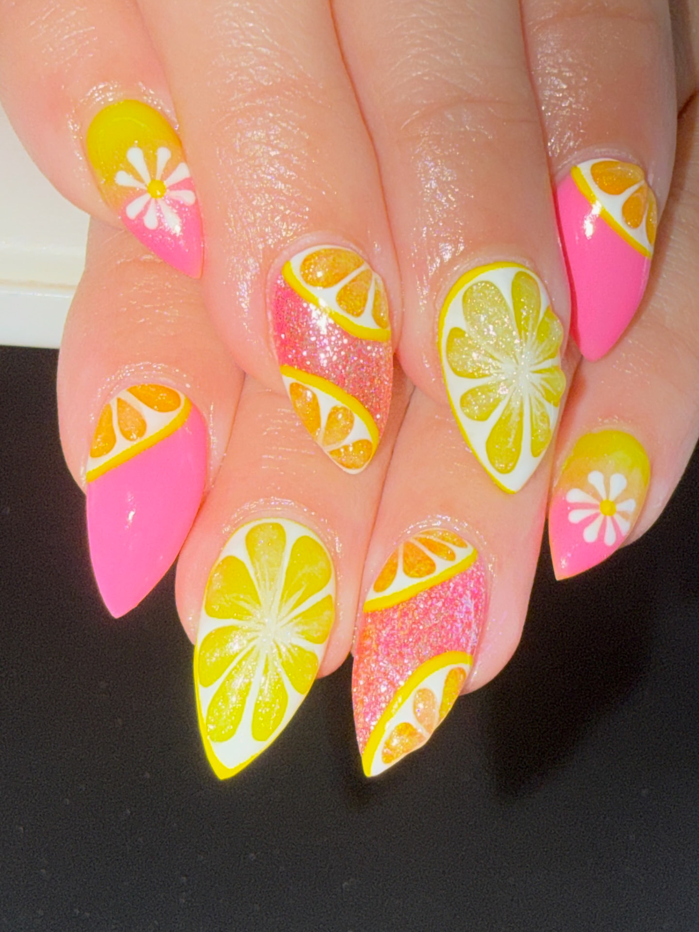 Pink and yellow almond nails with glitter, citrus slices and daisy art