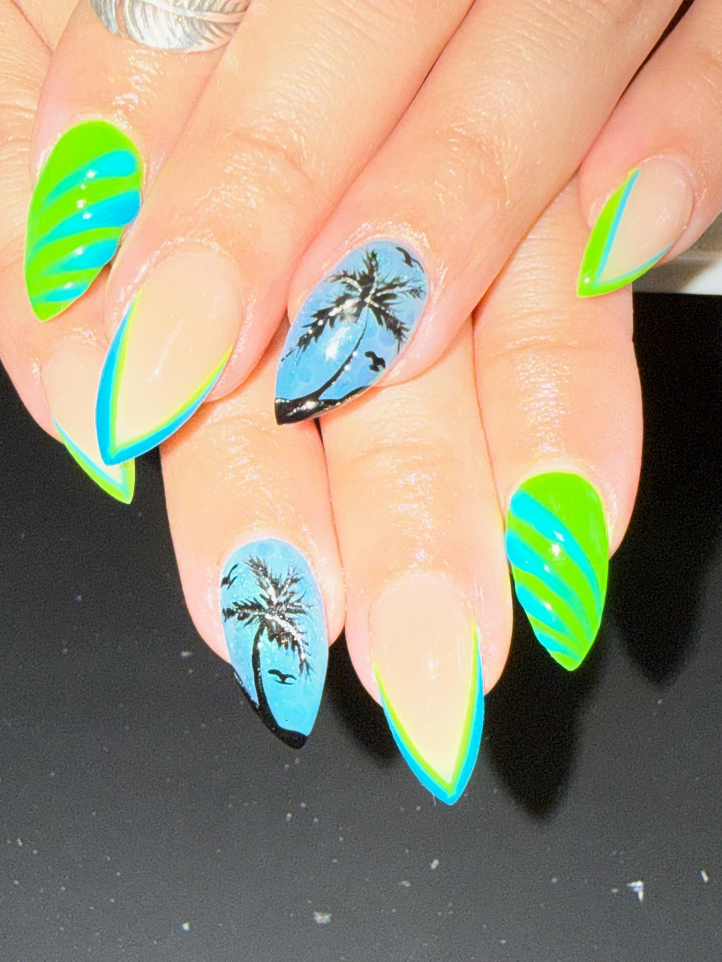 Neon green and blue almond nails with hand-painted palm trees
