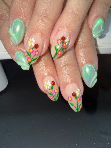 Green almond nails with hand-painted wildflowers and ladybugs