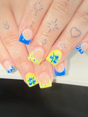 Short blue and yellow French-tip nails with hand-painted blueberry details
