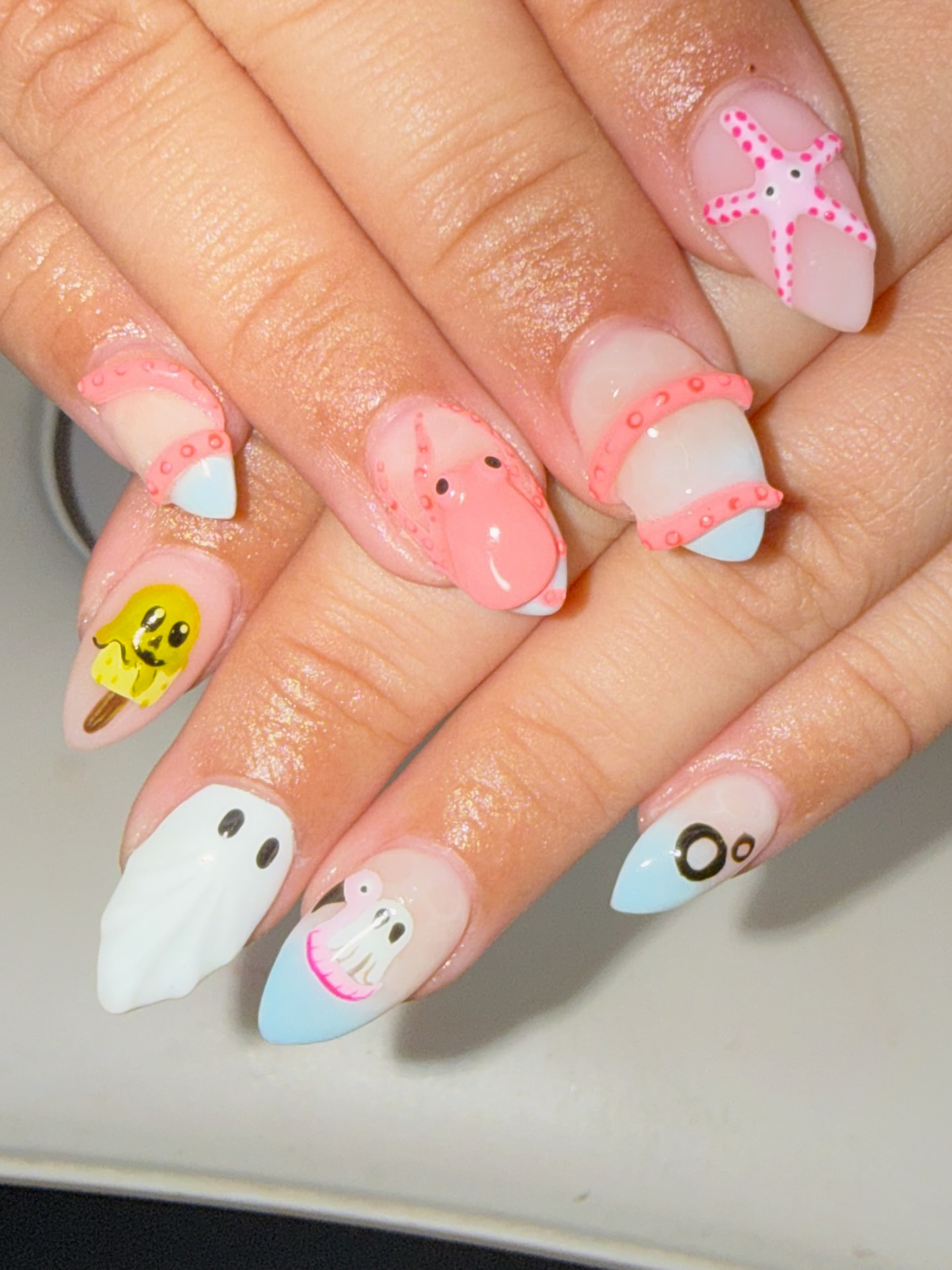 Pastel ocean-themed nails with sculpted sea character art